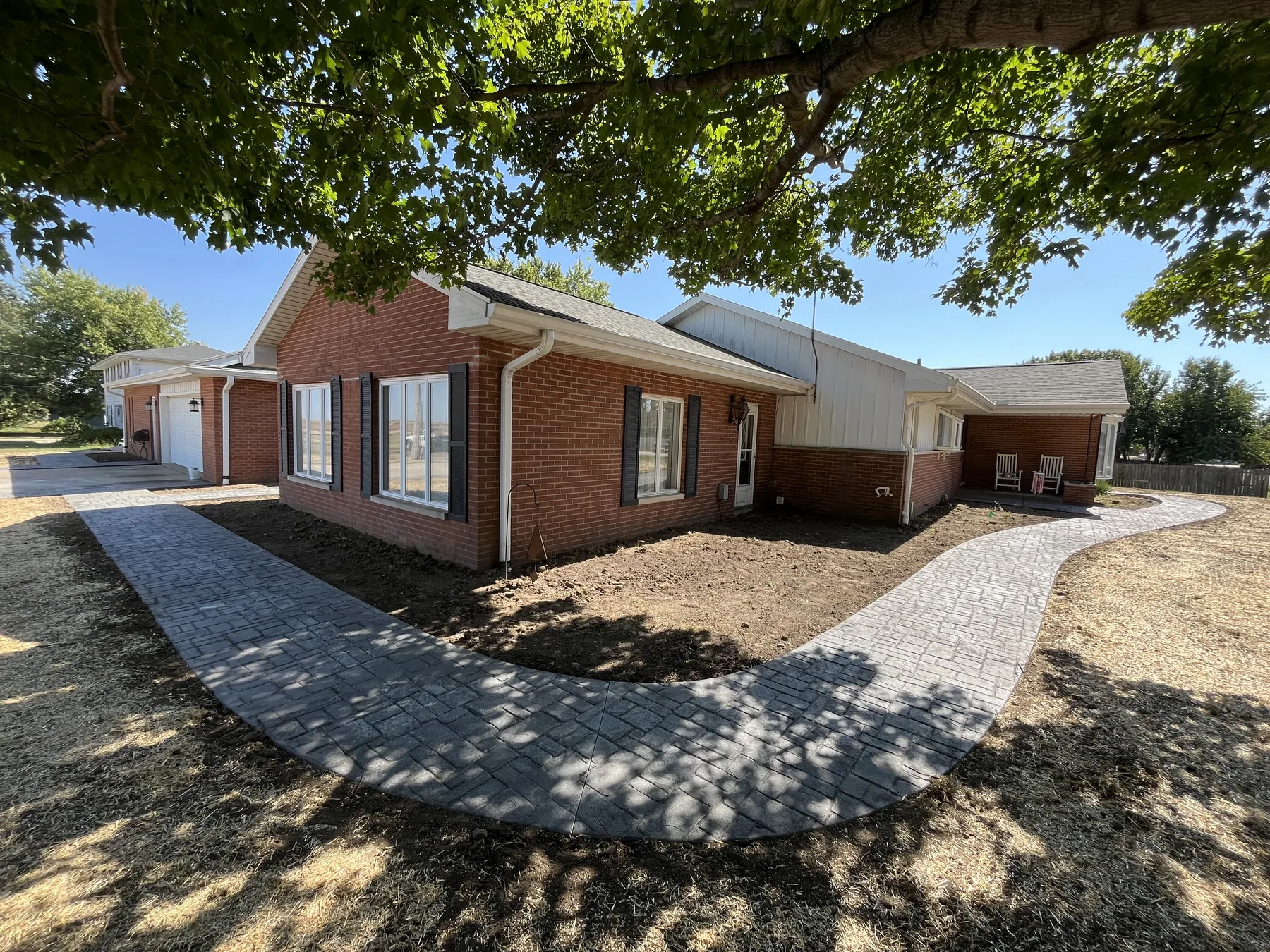 Stamped concrete walkway around a brick home