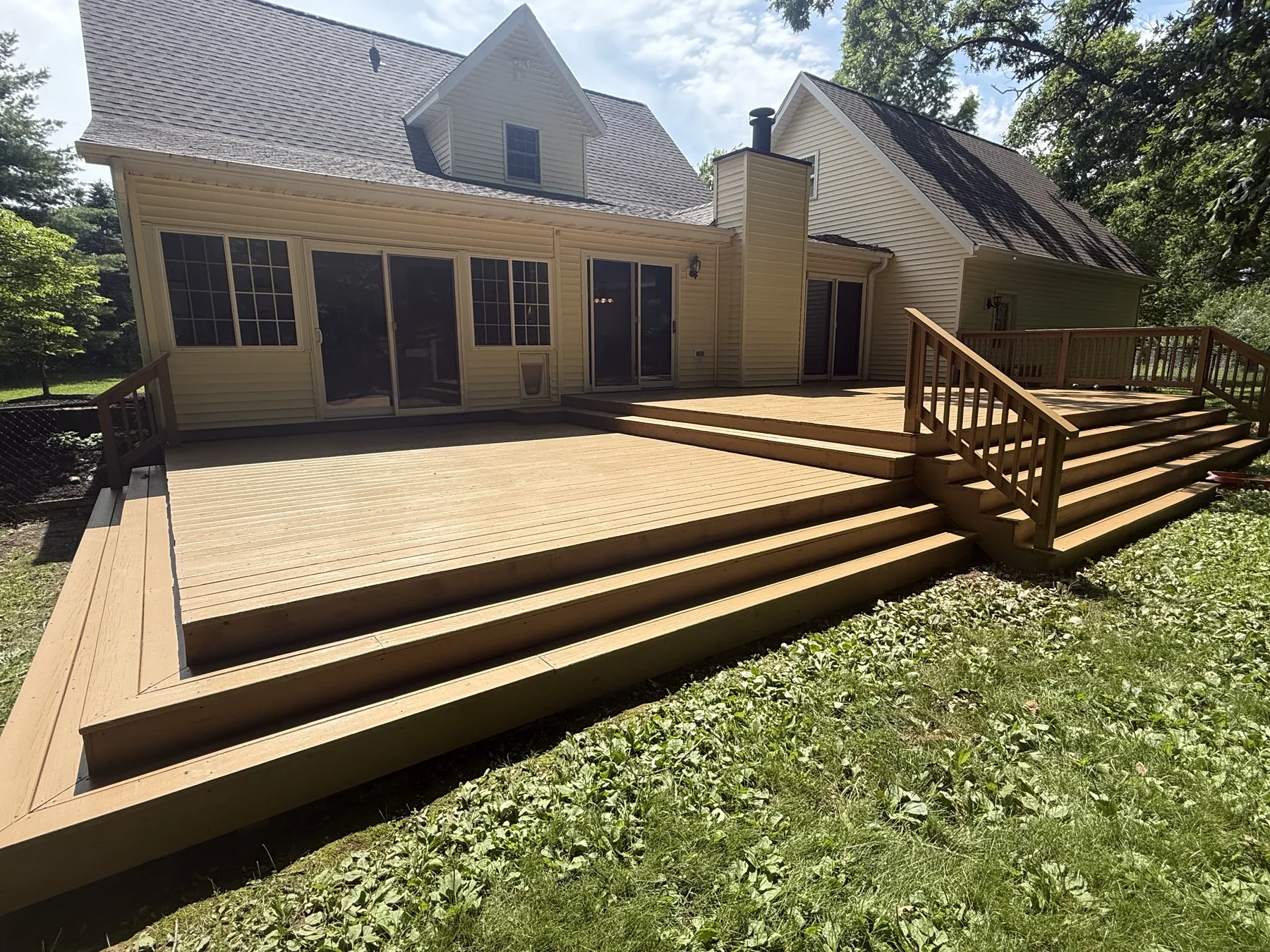 Natural wood backyard deck with steps and railings