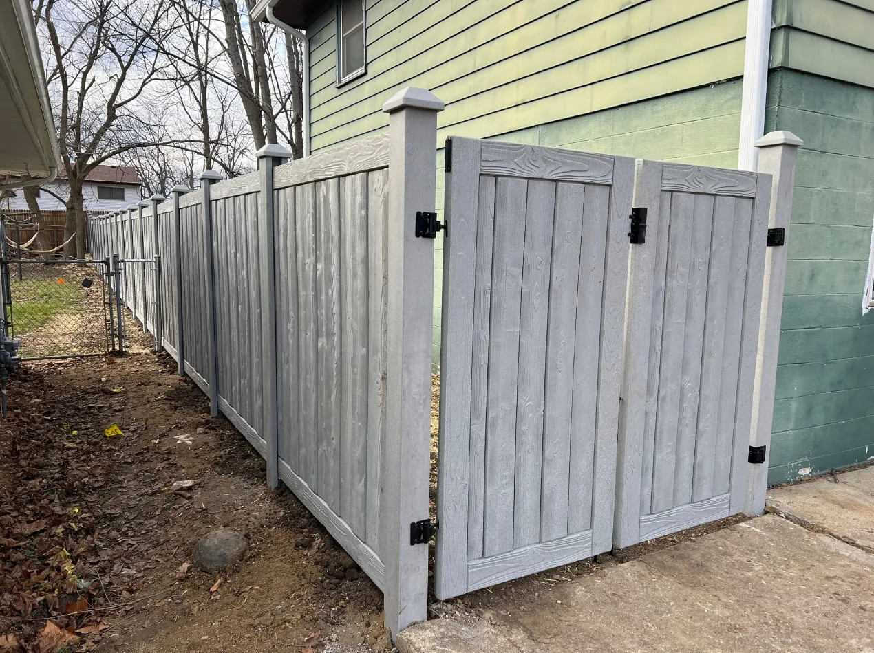 Gray privacy fence and gate beside a house