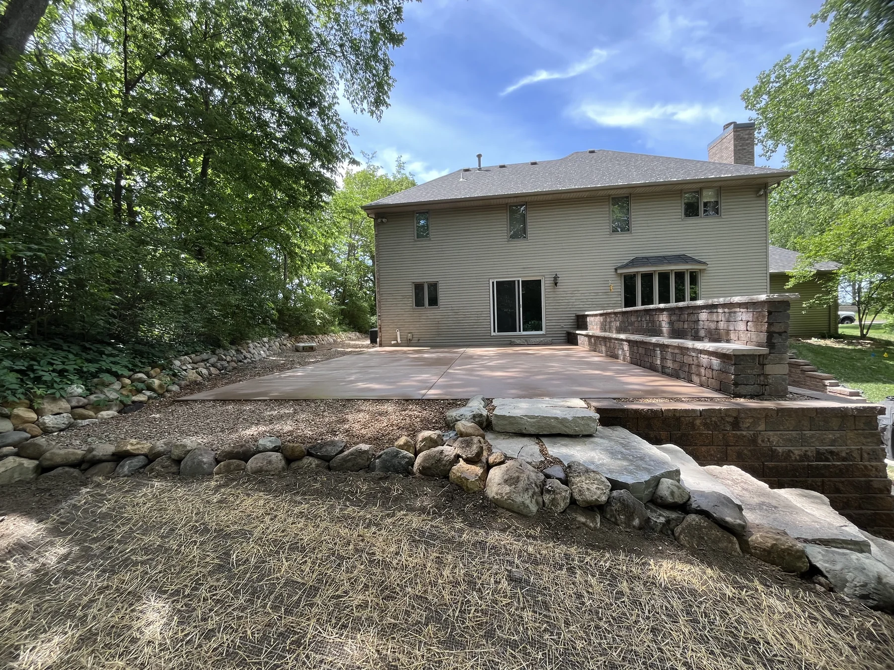 Retaining wall patio with boulder beds by Zehr Property Maintenance