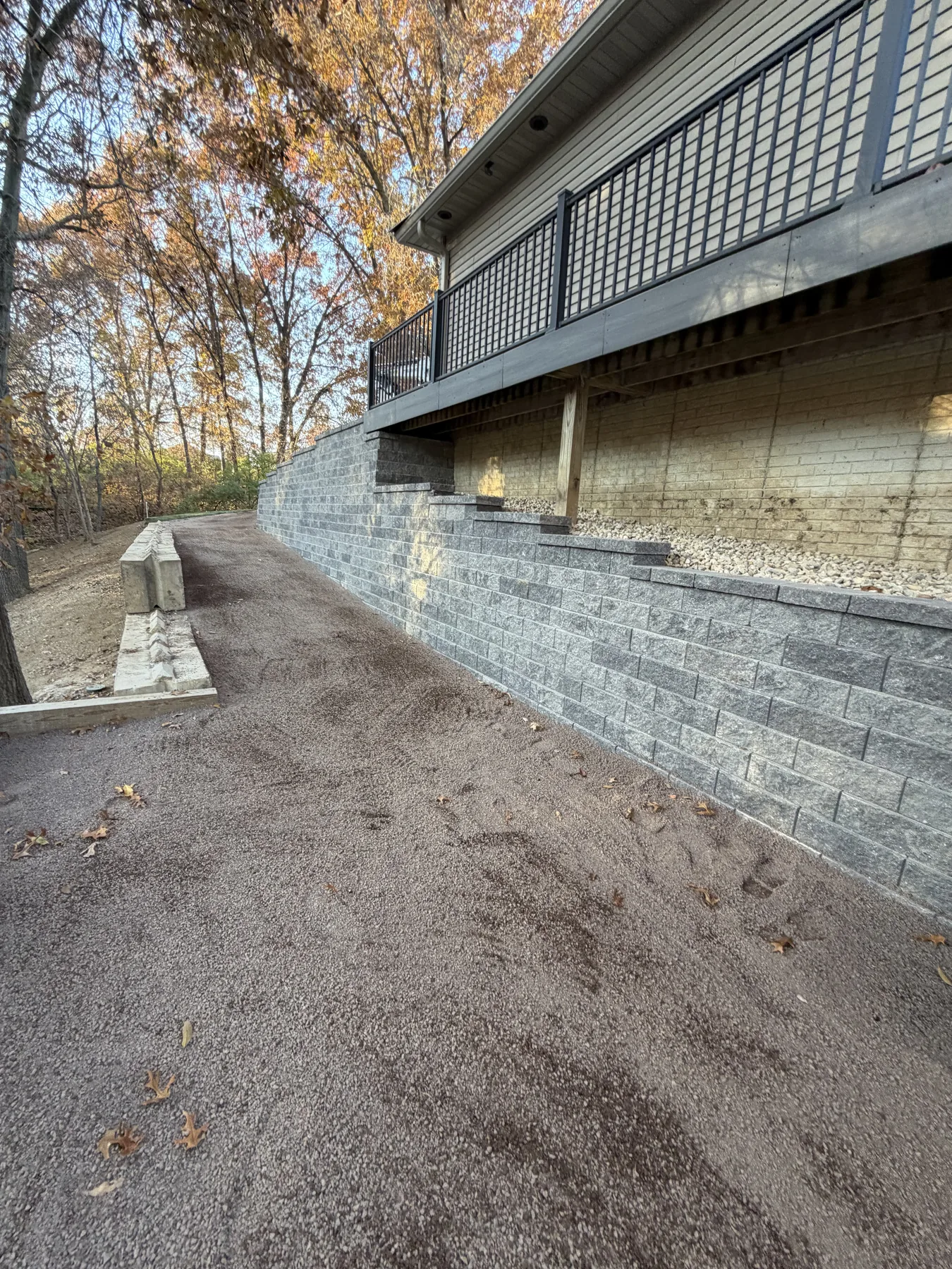Stacked stone retaining wall under a backyard deck