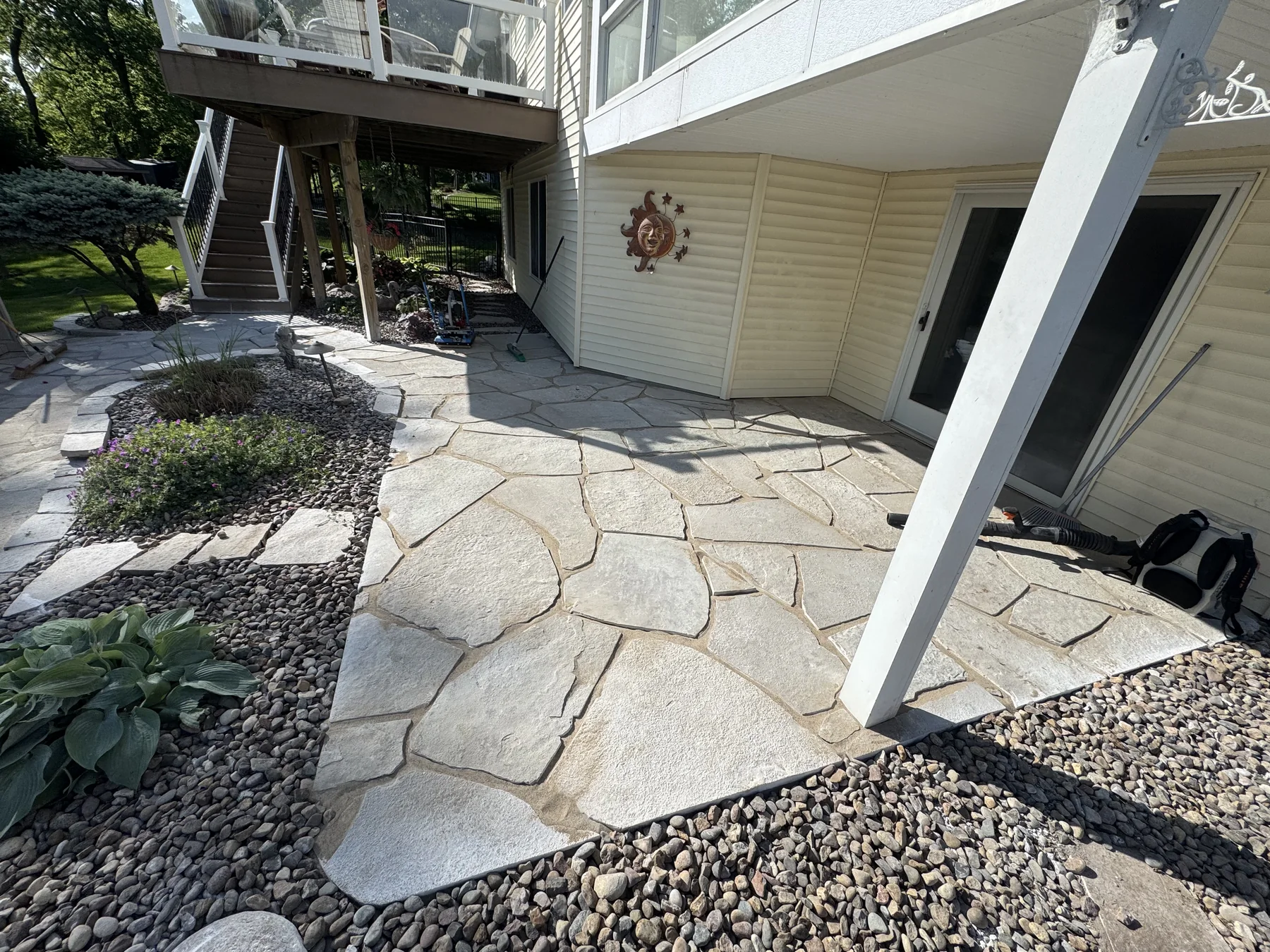 Flagstone patio and river rock beds by Zehr Property Maintenance