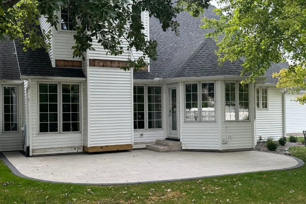 Finished patio and landscape installation beside a home